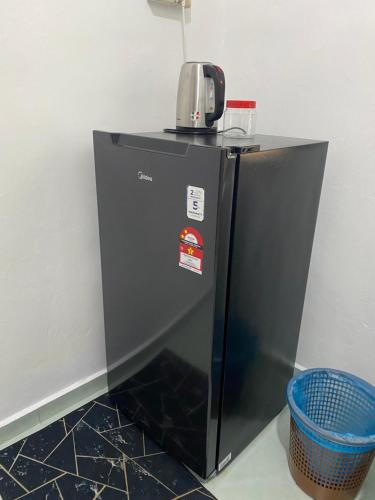 a black refrigerator with a coffee maker on top of it at Rumah Puteh Mersing Kecil ROOM FULLY AIR-CONDITIONED in Mersing