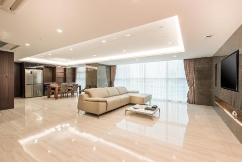 a living room with a couch and a tv at ENA Suite Hotel Namdaemun in Seoul