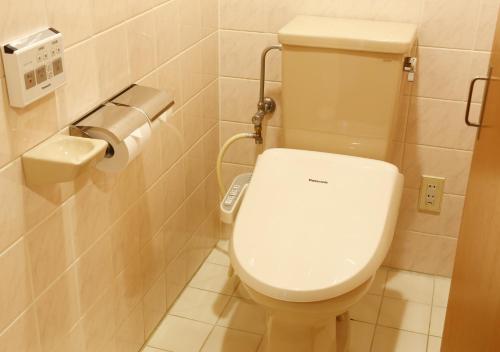 a bathroom with a toilet and a toilet paper dispenser at Hotel New Awaji in Sumoto