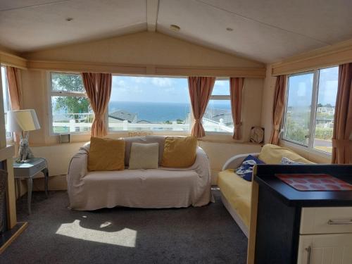 a living room with a couch and a view of the ocean at Haven Devon Cliffs Caravan in Budleigh Salterton