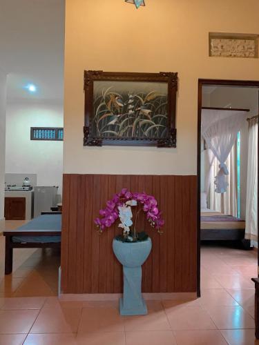 a room with a vase with flowers in it at Kukuh House Ubud in Ubud