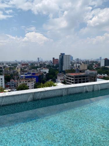 a swimming pool with a view of a city at Mexico City loft in the heart of Roma Norte steps away from Cibeles in Mexico City