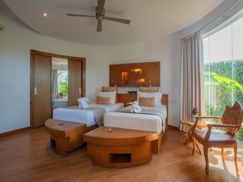 a hotel room with two beds and a table at Floating Leaf Eco Resort in Gianyar