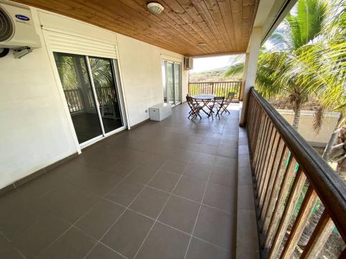 a balcony of a house with a table and chairs at Grande villa belle vue lagon kazcaillou in Saint-Paul