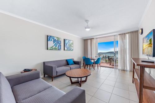 una sala de estar con un sofá y una mesa en Harbour View King Suite with Spa 1511, en Airlie Beach