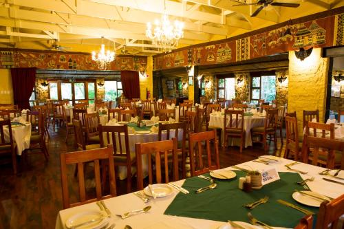 a dining room with tables and chairs and chandeliers at Misty Hills Country Hotel, Conference Centre & Spa in Muldersdrift