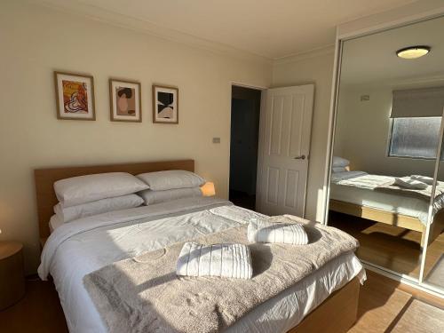 a bedroom with a large bed and a mirror at Cute & Light-filled Apartment - near Liverpool CBD in Liverpool