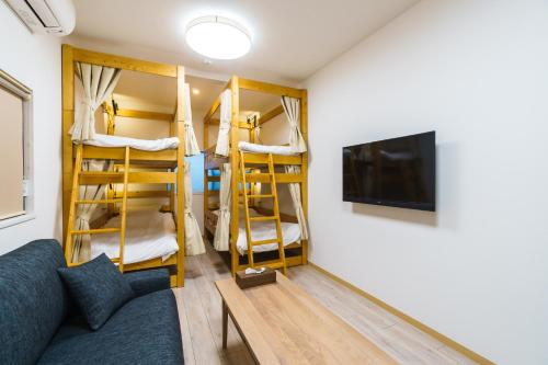a living room with a couch and a tv and bunk beds at 雅宿nf202最大6名USJまで20分最寄り駅から2分 in Osaka