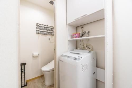 a small laundry room with a washer and dryer at 雅宿nf202最大6名USJまで20分最寄り駅から2分 in Osaka