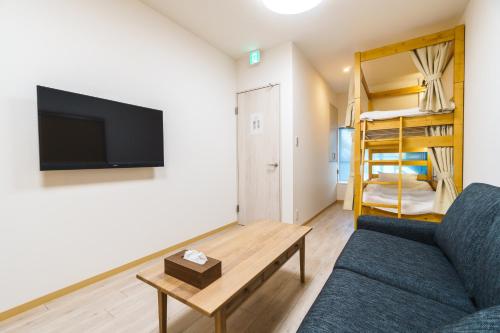 a living room with a couch and a table and a bunk bed at 雅宿nf202最大6名USJまで20分最寄り駅から2分 in Osaka