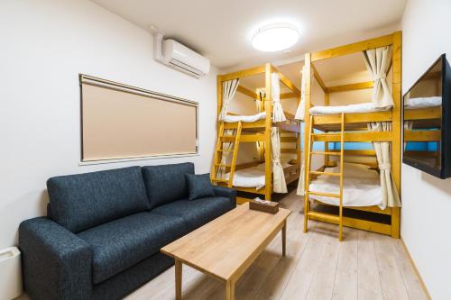 a living room with a couch and bunk beds at 雅宿nf202最大6名USJまで20分最寄り駅から2分 in Osaka