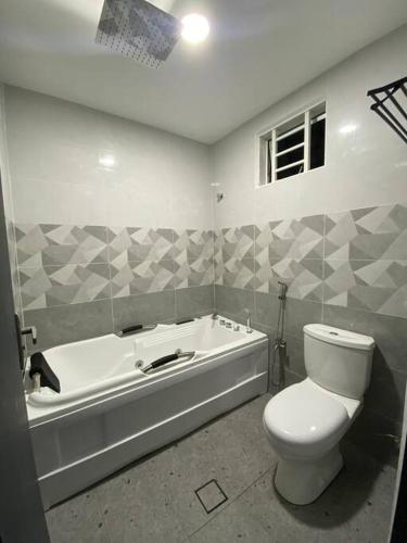 a bathroom with a toilet and a bath tub at Melur House - Private Pool, Jacuzzi, Bbq, Netflix, PS4 in Malacca