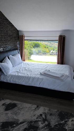 a bedroom with a large bed with a large window at Casa 3 Catei Veseli in Seciu