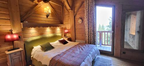 une chambre avec un lit dans une cabane en bois dans l'établissement Duplex Luxueux 200m2 Niché sur les Pistes - Paradis Lodge pour 14 Personnes, à Bourg-Saint-Maurice