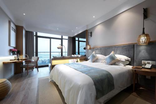 Una habitación de hotel con una cama grande y un escritorio. en Zhoushan Yibo Hotel, en Zhengjia