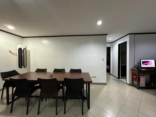 a dining room with a wooden table and black chairs at Clark stay in Fort Stotsenburg