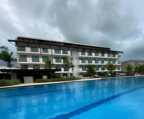 a hotel with a large swimming pool in front of it at Flat Luxo no Laguna Beach in Porto De Galinhas