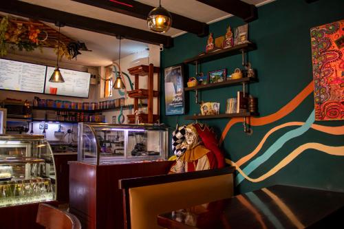 キトにあるSan Marcos Cultural & Guesthouseのカウンターに座っている男性の像があるレストラン