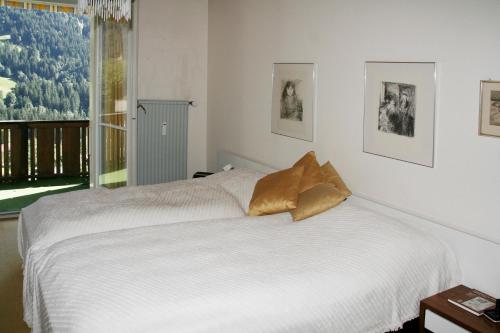 グリンデルワルトにあるシャレー ツア ヘーエのベッドルーム1室(ベッド2台、窓付)