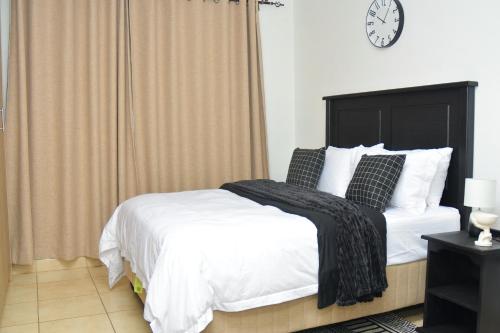 a bedroom with a bed and a clock on the wall at Home for Us Self catering in Duvhapark