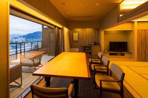a room with a balcony with a table and chairs at Hotel New Awaji in Sumoto