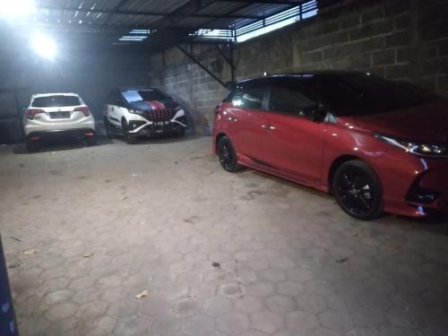 two cars are parked in a garage at Griyo Kartika backpacker in Probolinggo