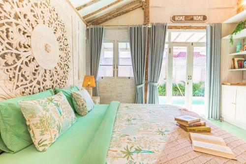 ein Schlafzimmer mit einem großen Bett mit Büchern darauf in der Unterkunft SooBali Mint Cottage Sanur 1BR in Sanur