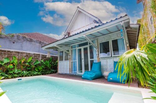 eine Villa mit einem Swimmingpool vor einem Haus in der Unterkunft SooBali Mint Cottage Sanur 1BR in Sanur