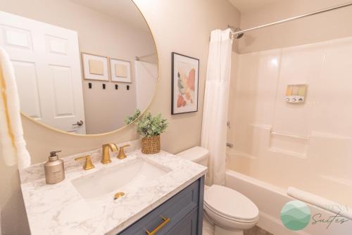 a bathroom with a sink and a toilet and a mirror at Susitna Suites in Wasilla