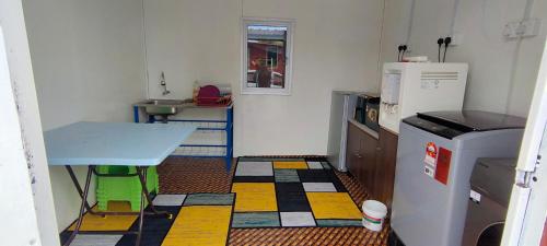 eine kleine Küche mit Tisch und Kühlschrank in der Unterkunft Village View Cottage Roomstay in Kemasik