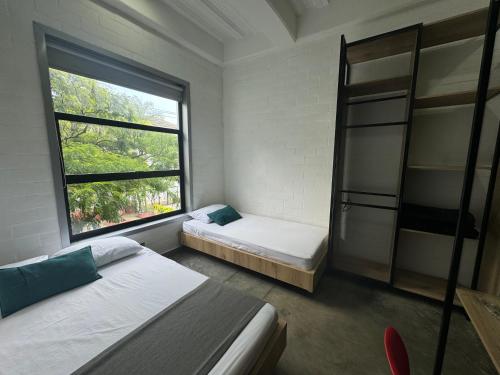 a bedroom with two beds and a window at Hotel Living Box San Fernando Cali in Cali