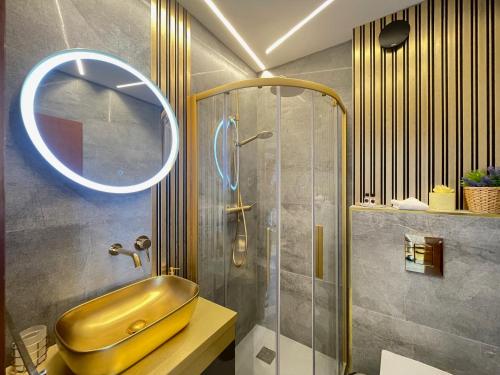 a bathroom with a gold sink and a shower at Duplex Penthouse Aparthotel Rosa in Podčetrtek