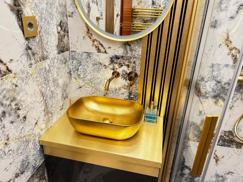 a gold sink on a counter in a bathroom at Duplex Penthouse Aparthotel Rosa in Podčetrtek