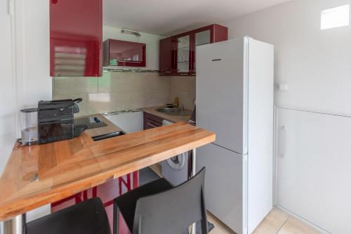 a kitchen with a white refrigerator and a wooden counter top at COQUET STUDIO dans un CADRE IDYLLIQUE in Sainte-Luce