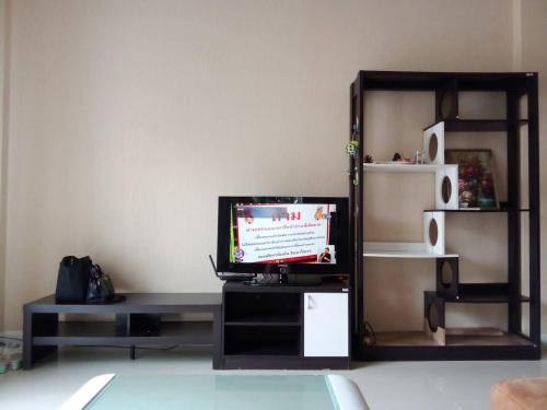 a living room with a tv on a table at Chiang Mai Home in Chiang Mai
