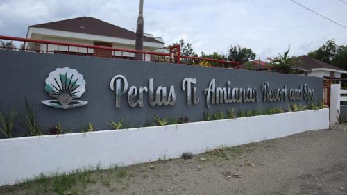 a retaining wall with a sign for a resort at Perlas TI Amianan Resort and Spa in Laoag