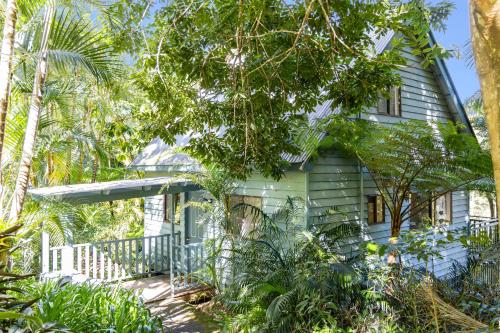 a green house with trees in front of it at Montville Country Cabins in Montville