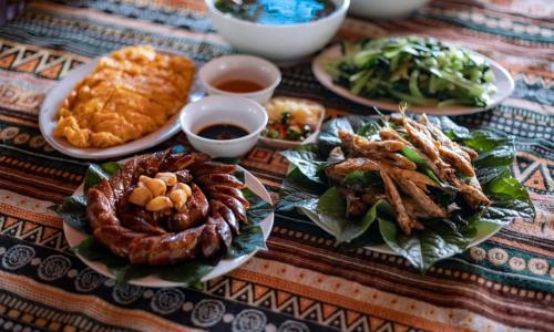a table with plates of food on a table at Nasan Green Farm in Cao Bằng
