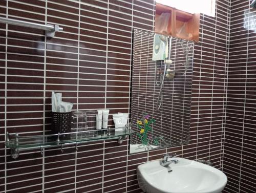 a black tiled bathroom with a sink and a mirror at Angkor Sandra Villa in Siem Reap
