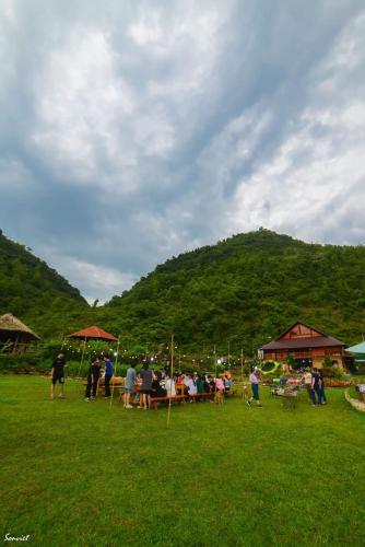 a group of people sitting under umbrellas in a field at Nasan Green Farm in Cao Bằng