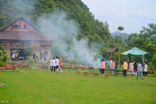 a group of people walking in a field near a building at Nasan Green Farm in Cao Bằng