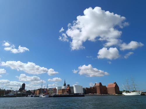 a view of a city from the water with clouds at Suite - Mein Ankerplatz in Stralsund