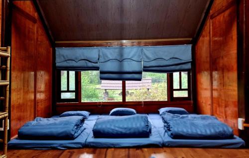 a bed in a room with a window at Nasan Green Farm in Cao Bằng