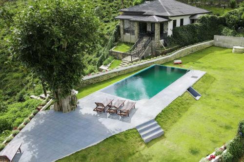 an overhead view of a swimming pool with chairs and a house at Benito Bungalow, Haputale by The Serendipity Collection in Haputale