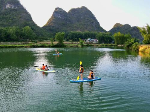 a group of people on paddle boards on a river at Nasan Green Farm in Cao Bằng