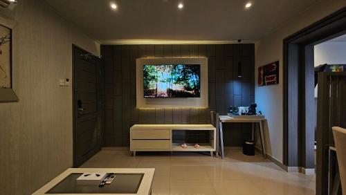 a living room with a tv on a wall at 1O1 URBAN Jakarta Thamrin in Jakarta