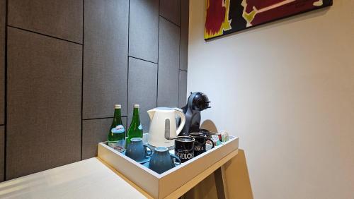 a kitchen counter with a coffee maker and bottles at 1O1 URBAN Jakarta Thamrin in Jakarta