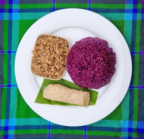 a plate of food with rice and vegetables on a table at Nasan Green Farm in Cao Bằng