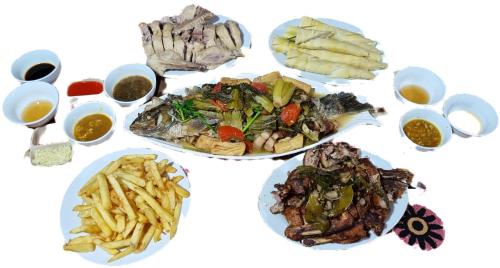 a white table with plates of food and french fries at Nasan Green Farm in Cao Bằng