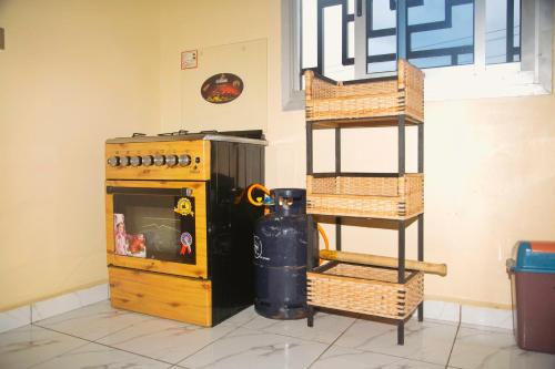 a kitchen with a stove and a shelf with baskets at Supreme hosts in Yaoundé